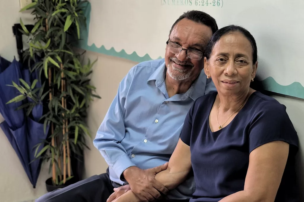 Dos personas mayores sentadas sonríen