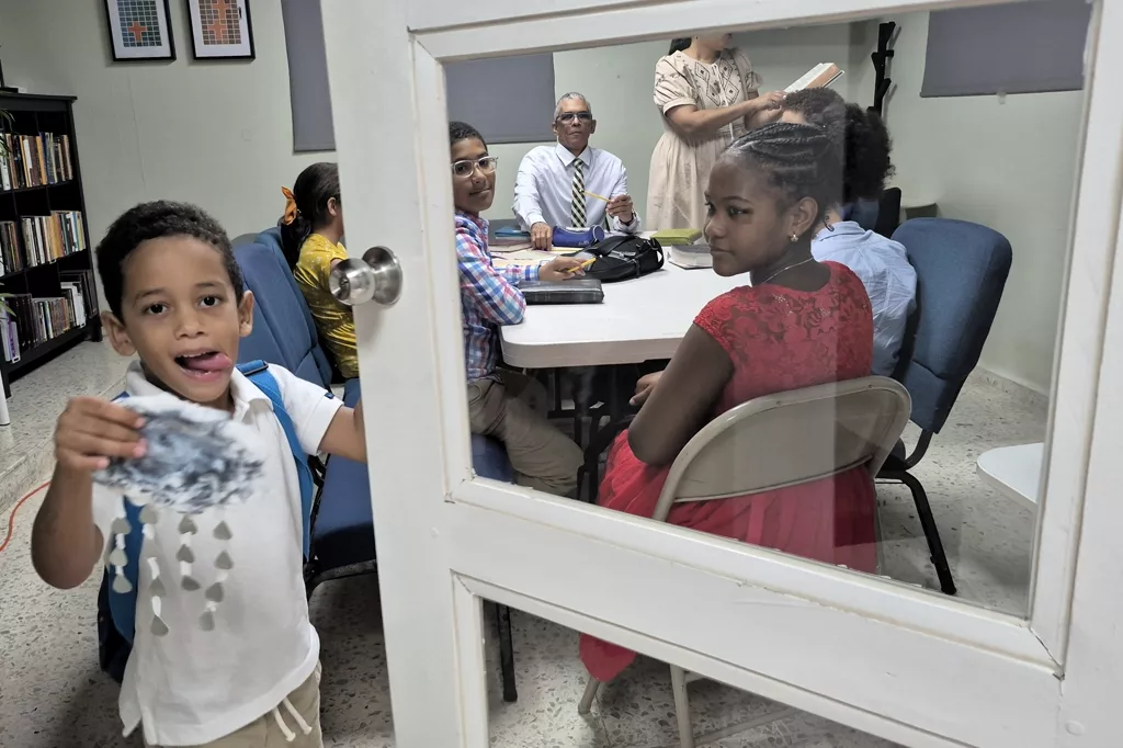 Niños alrededor de una mesa con un adulto durante una clase